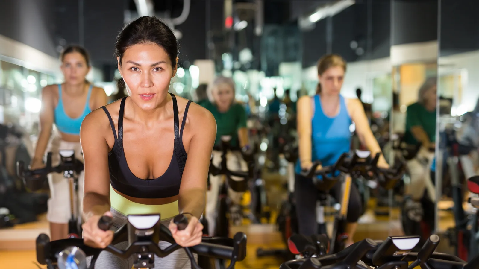 Zwei Teilnehmende auf Indoor-Bikes im Cycling-Kurs